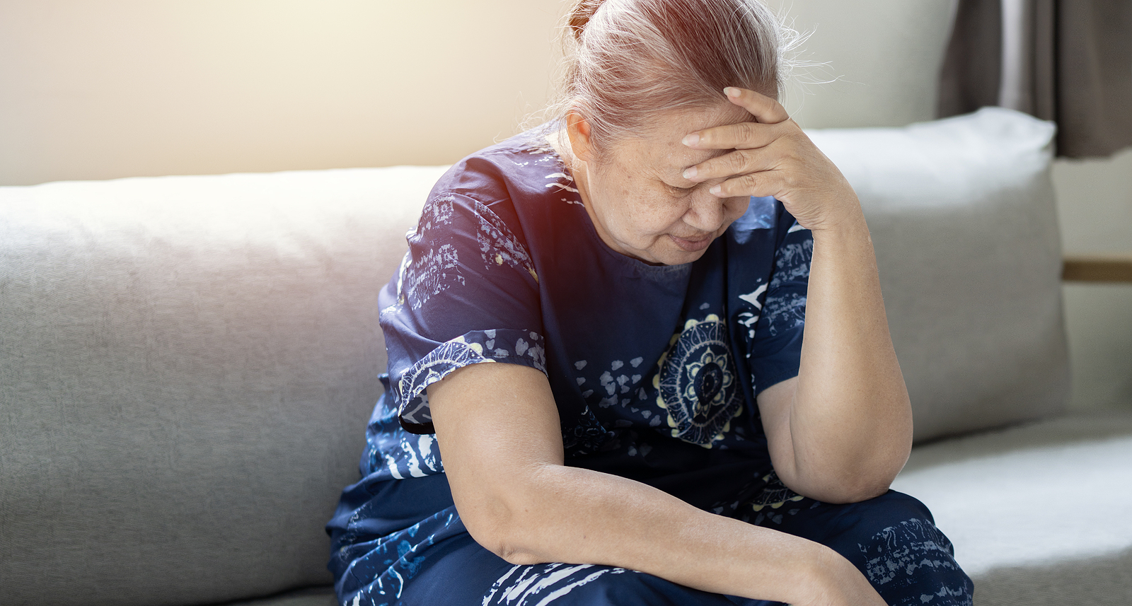 Pensive Old Mature Woman Sitting On Couch Alone At Home, Sufferi